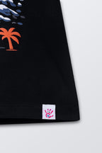 Black tee hem close-up with small white tag label near bottom