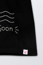 Close-up of black T-shirt hem with small logo patch tag