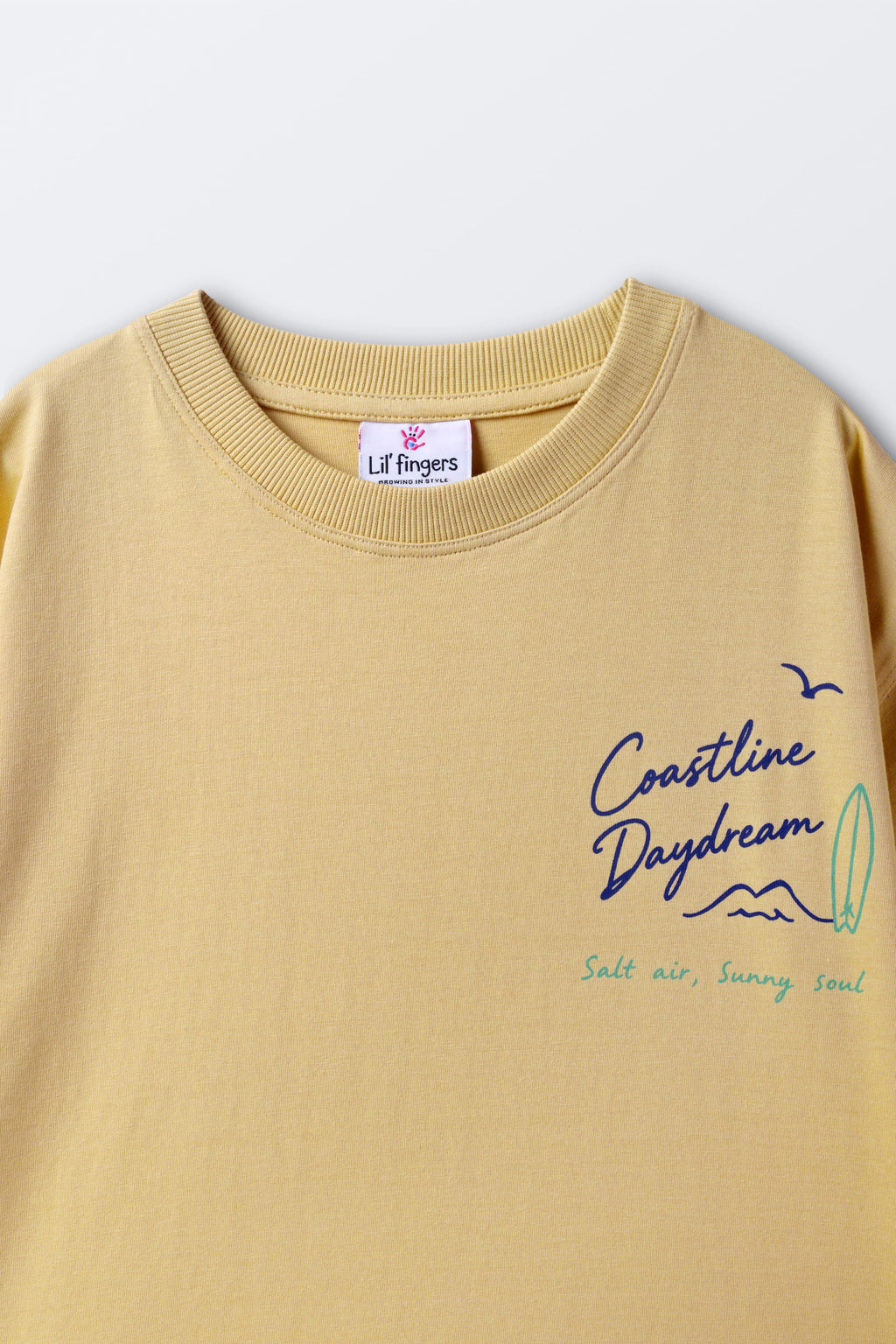 Sand yellow crewneck tee with small chest graphic and interior neck label.