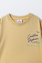 Sand yellow crewneck tee with small chest graphic and interior neck label.