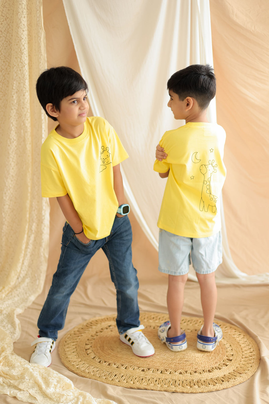 Yellow kids tee with giraffe embroidery and small back print, side view