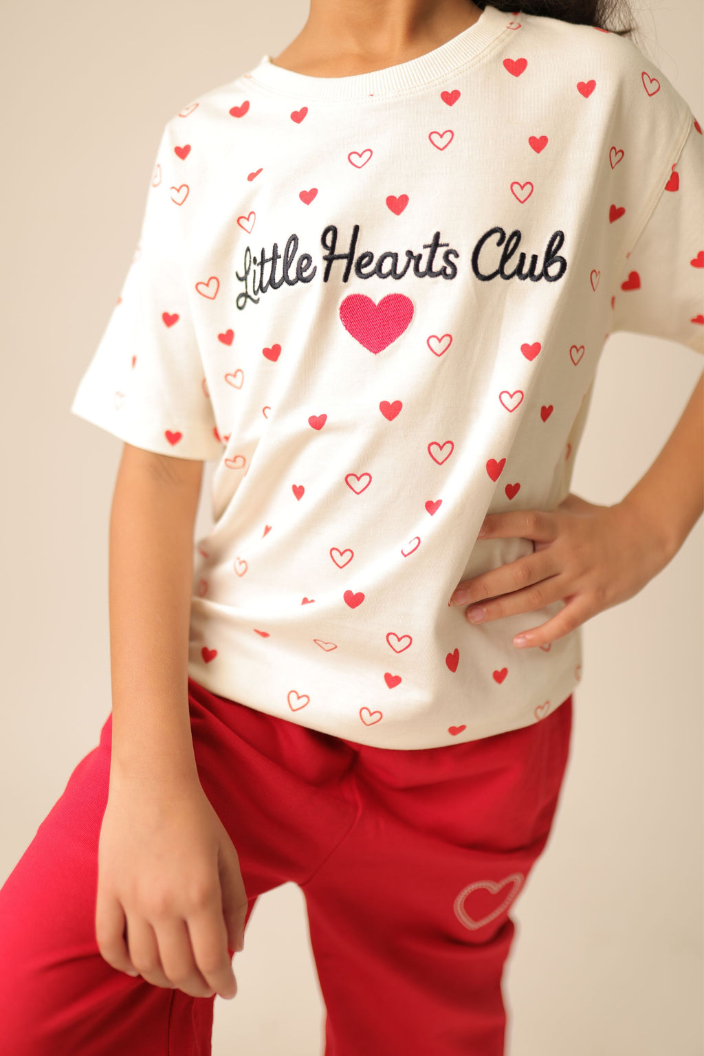 Off-white comfort tee with allover red heart print and 'Little Hearts Club' graphic