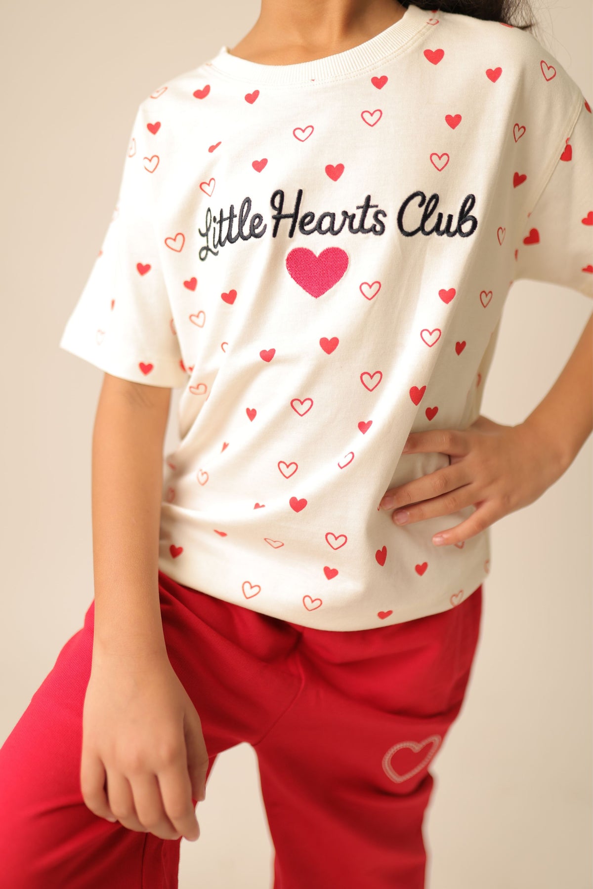 Off-white comfort tee with allover red heart print and 'Little Hearts Club' graphic