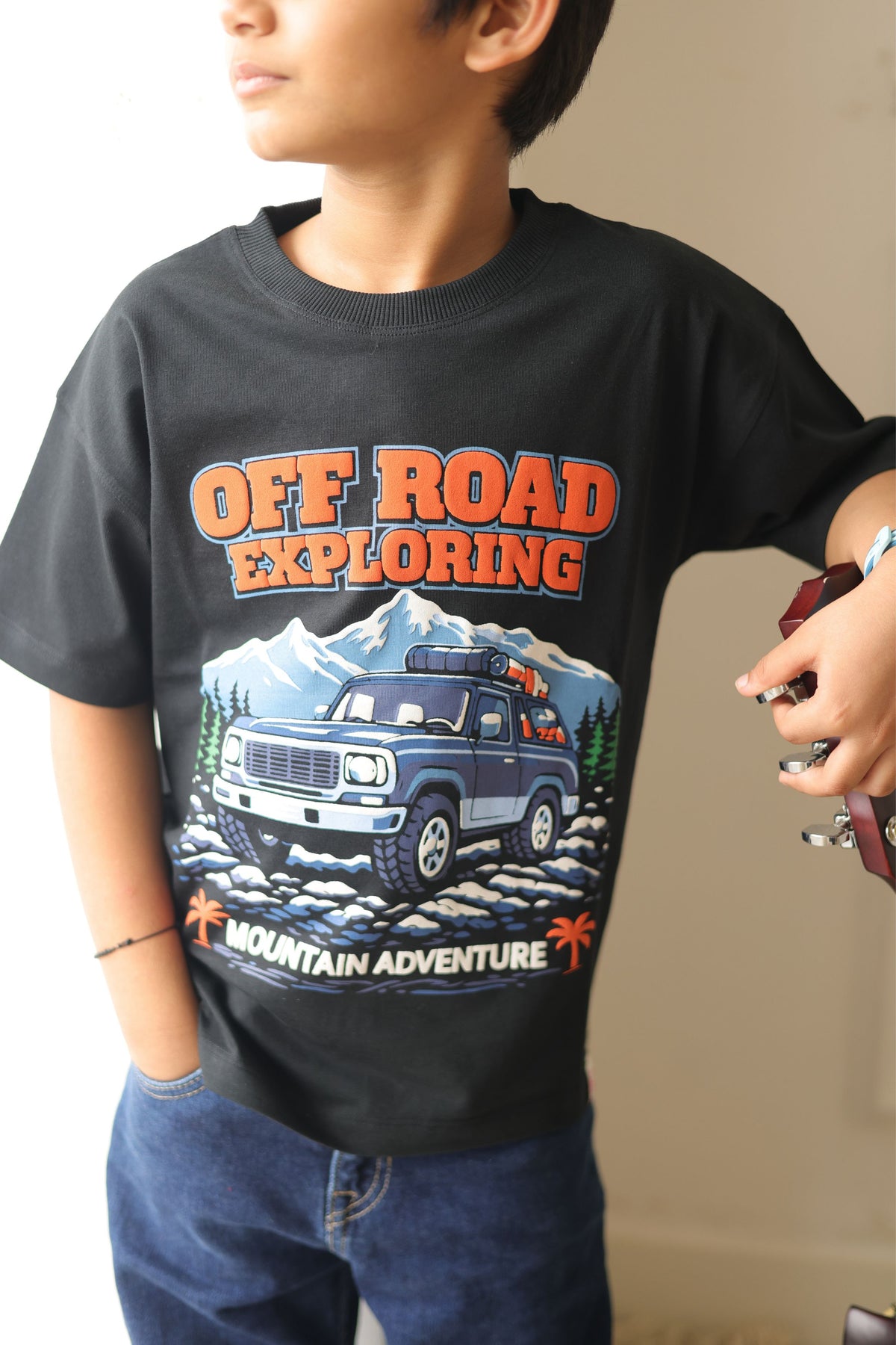 Black comfort tee with Off Road Exploring puff-print graphic worn by child