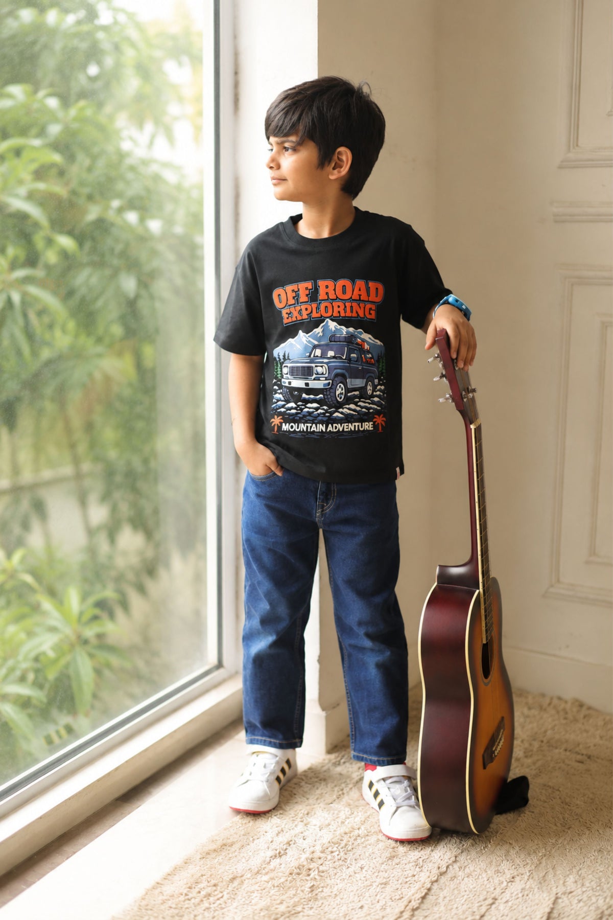 Black Off Road Exploring graphic tee on child, paired with blue jeans and sneakers