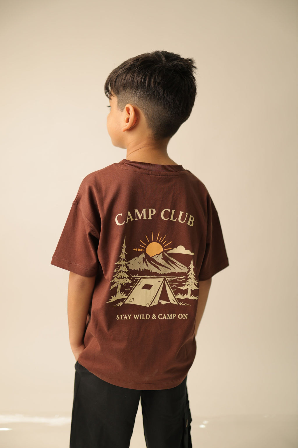Brown kids' T-shirt back view with “CAMP CLUB” graphic and “STAY WILD & CAMP ON”