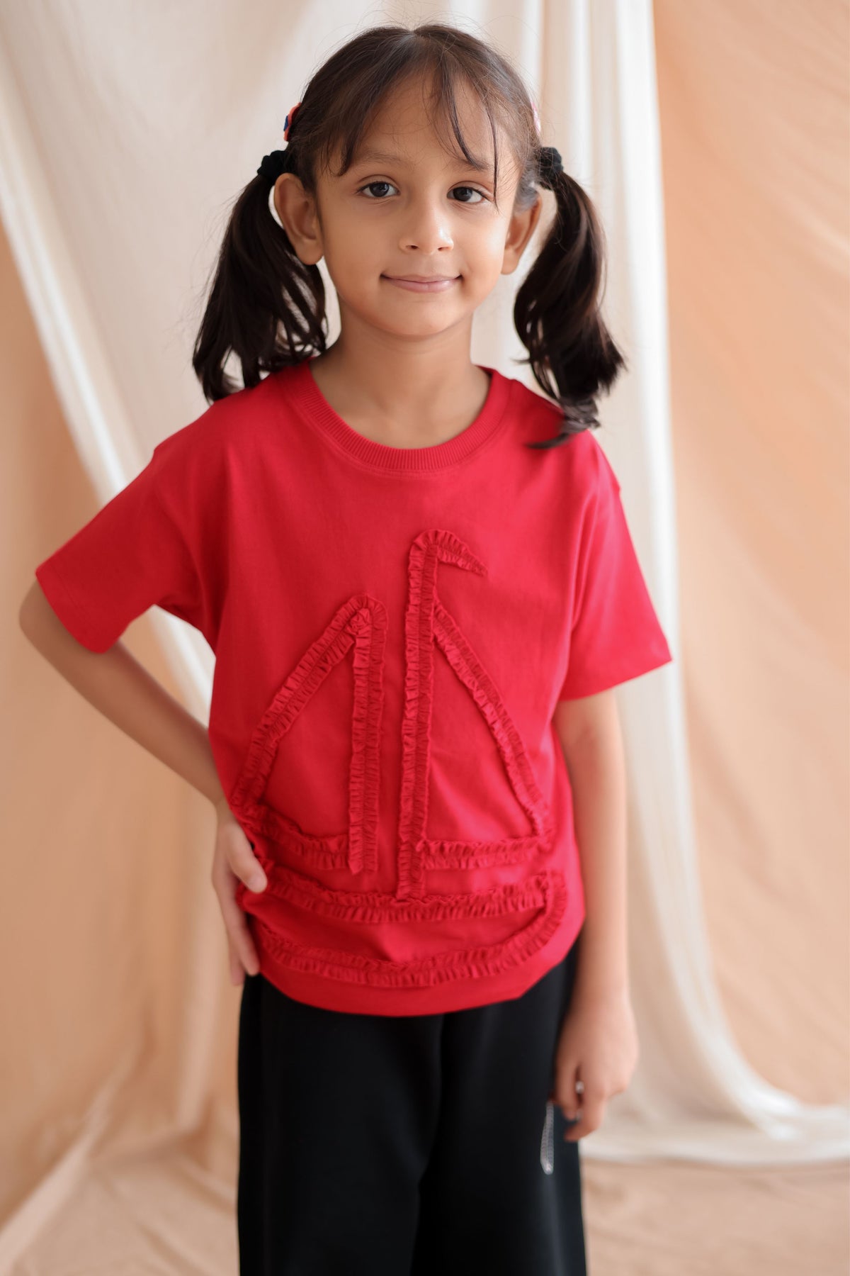 Red kids round-neck tee with boat-shaped self-fabric trim at chest