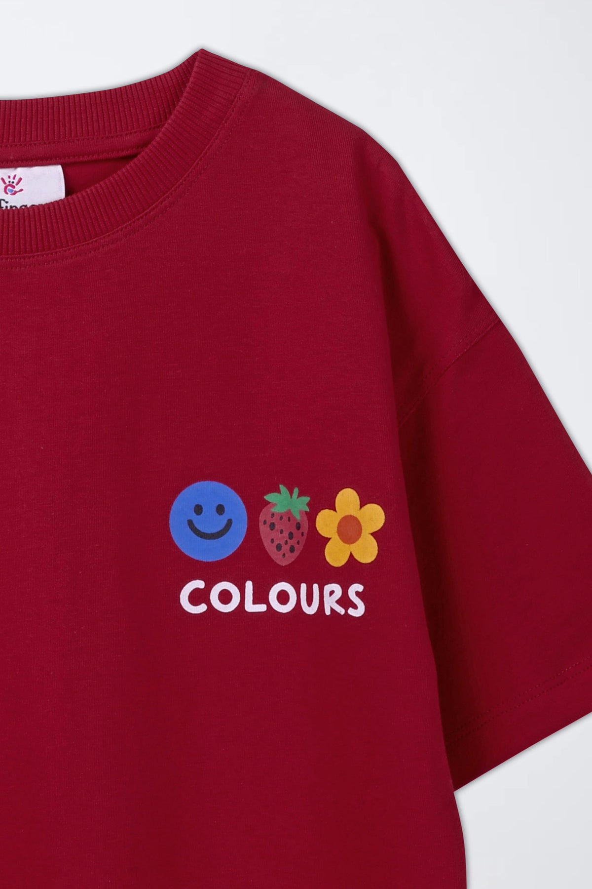 Red T-shirt close-up: COLOURS smiley, pineapple and flower print