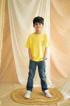 Yellow kids comfort tee with giraffe and cloud line embroidery, front view