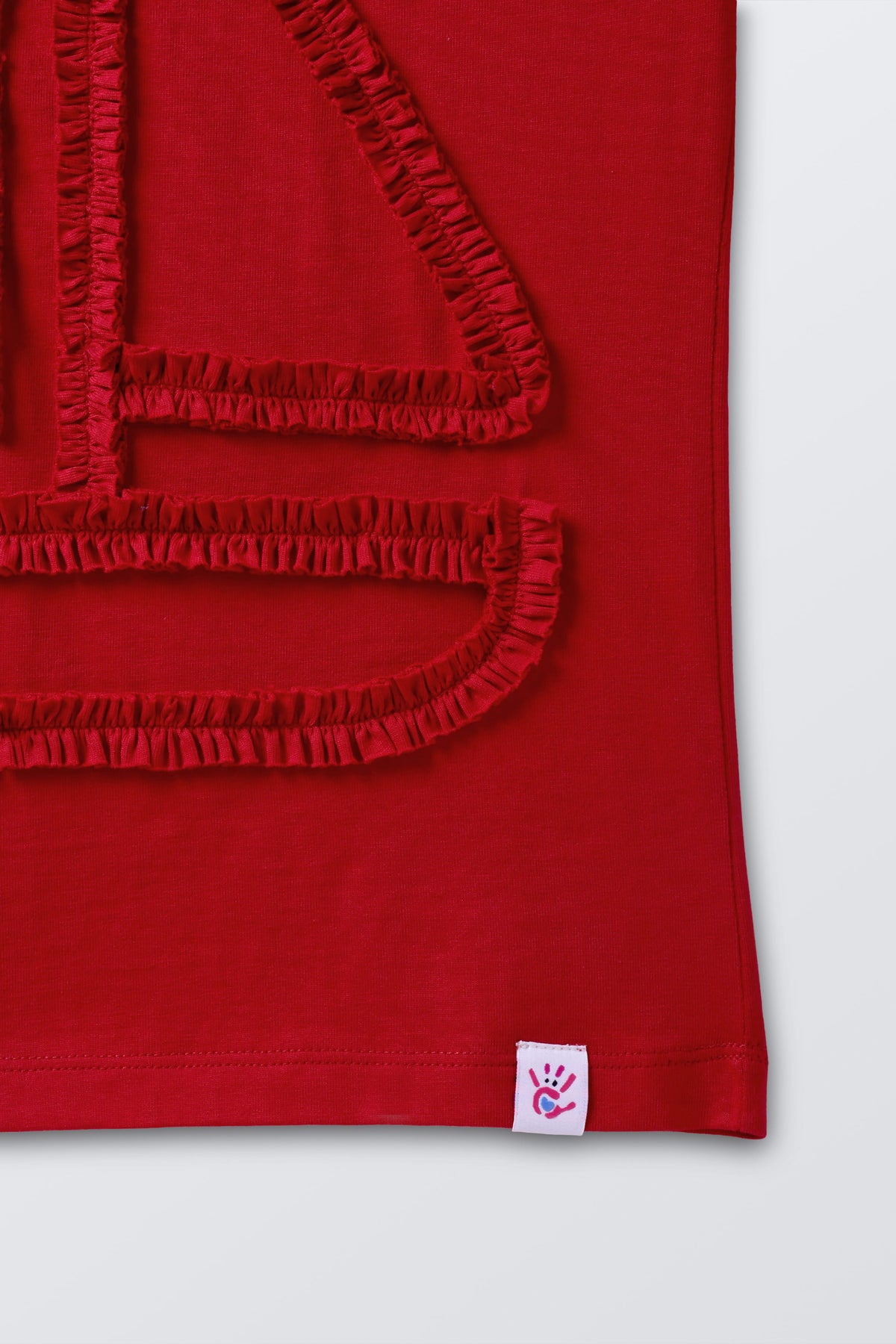 Red tee with boat appliqué and small logo patch at hem