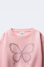 Girl's blush pink sweatshirt with sequined butterfly beadwork on the front