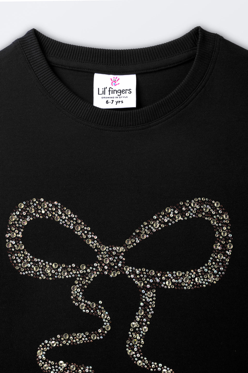 Black long-sleeve tee with close-up gold-toned bead bow detail on front