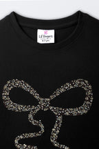Black long-sleeve tee with close-up gold-toned bead bow detail on front
