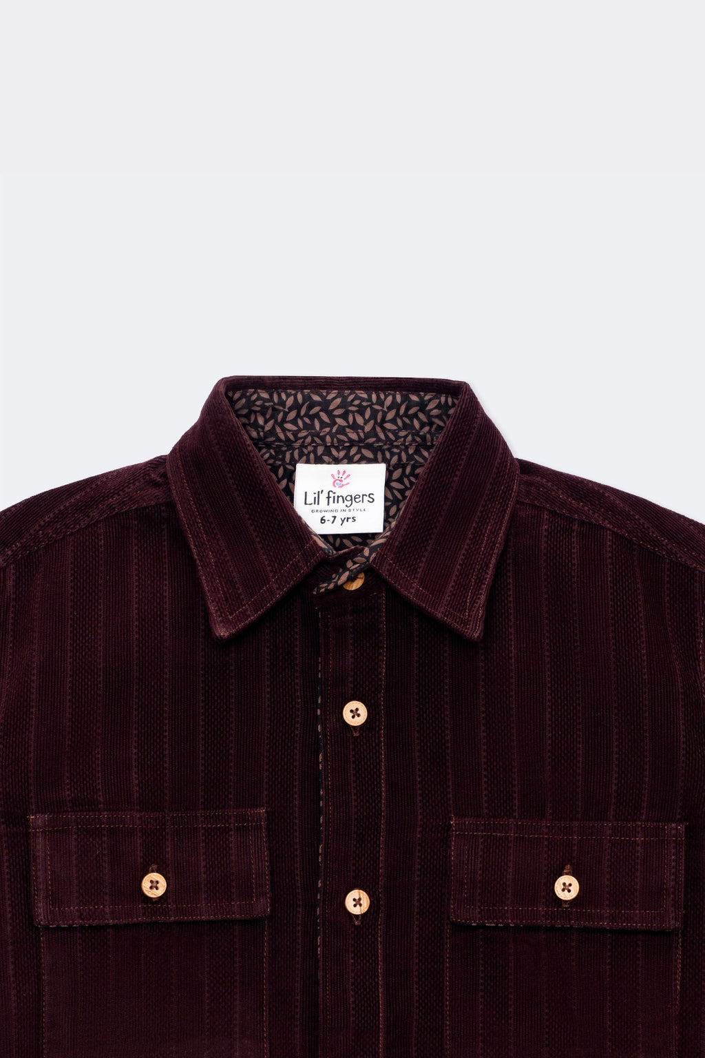 Burgundy corduroy boys button-up with two chest pockets and patterned inner collar