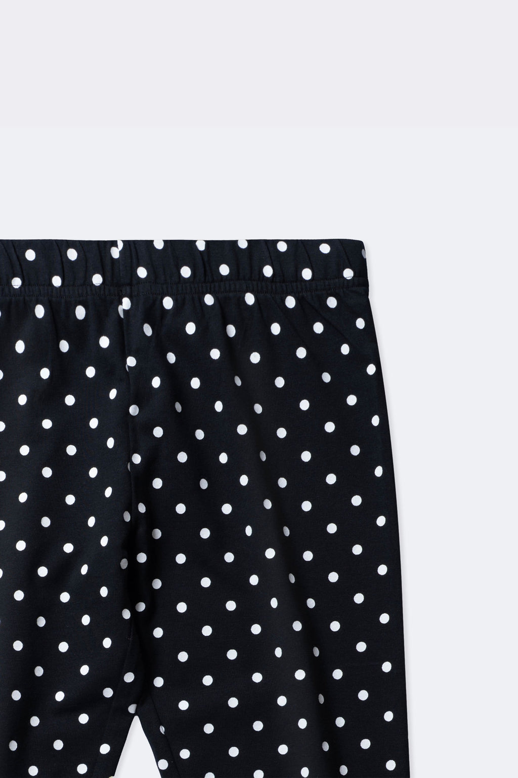 Black polka dot leggings close-up with ruched elastic waistband and allover dots