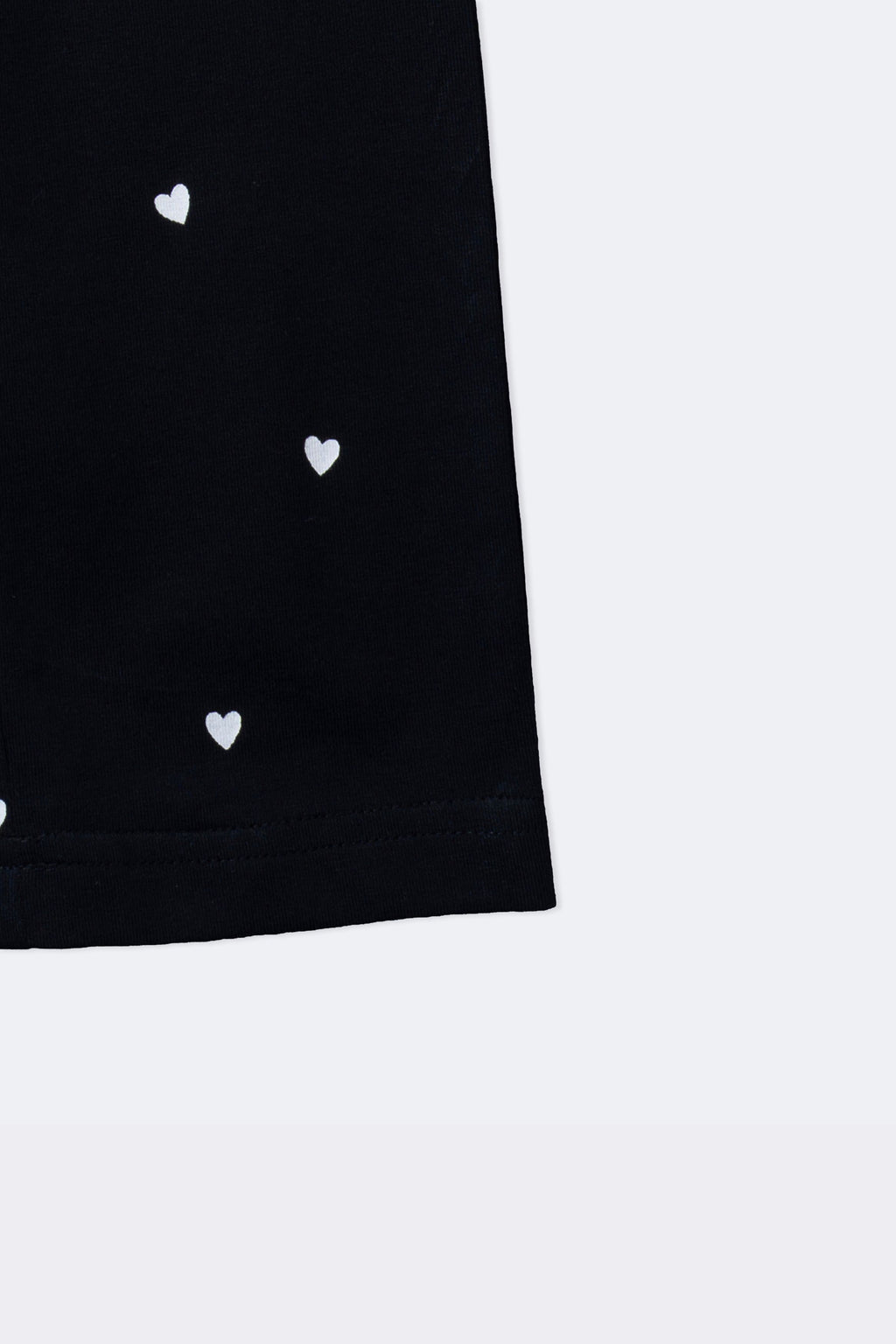 Black leggings with mini white hearts print, visible side and straight hem
