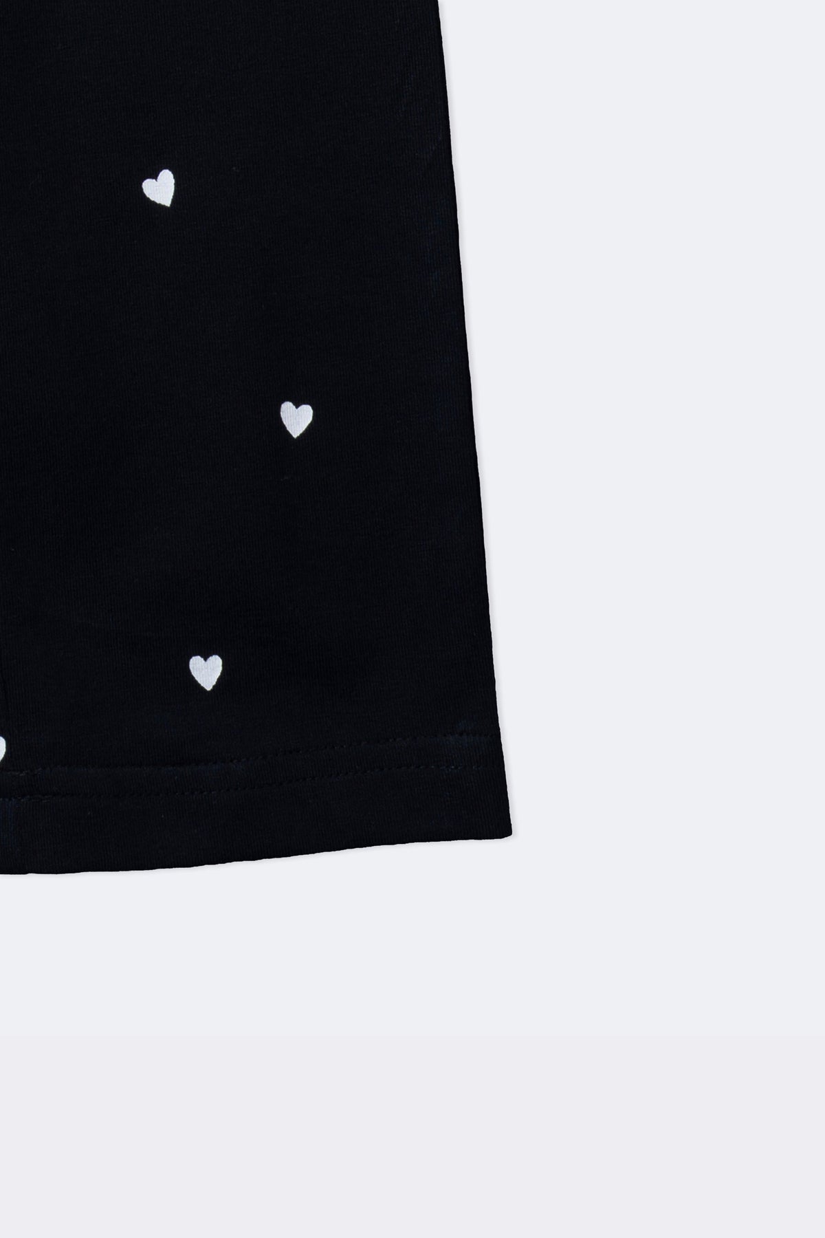 Black leggings with mini white hearts print, visible side and straight hem