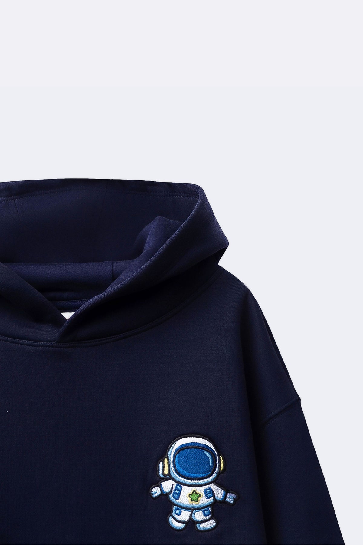 Navy hoodie close-up with astronaut embroidery on front pocket area