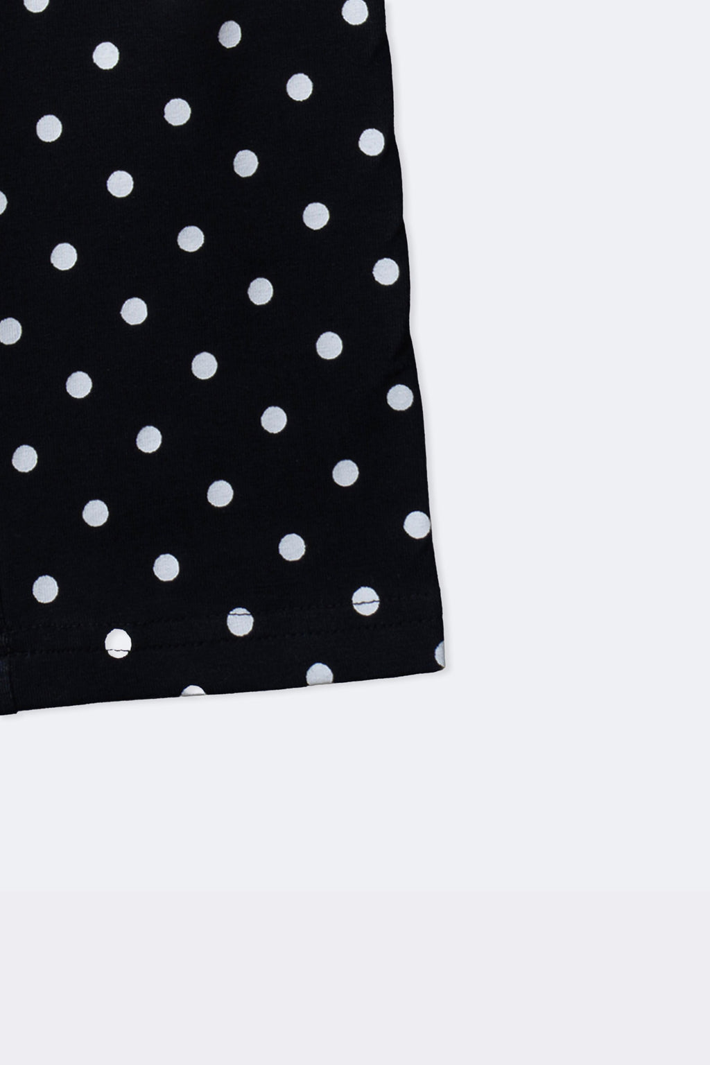 Black polka dot leggings with cuffed hem and scattered white dot pattern