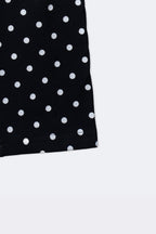 Black polka dot leggings with cuffed hem and scattered white dot pattern