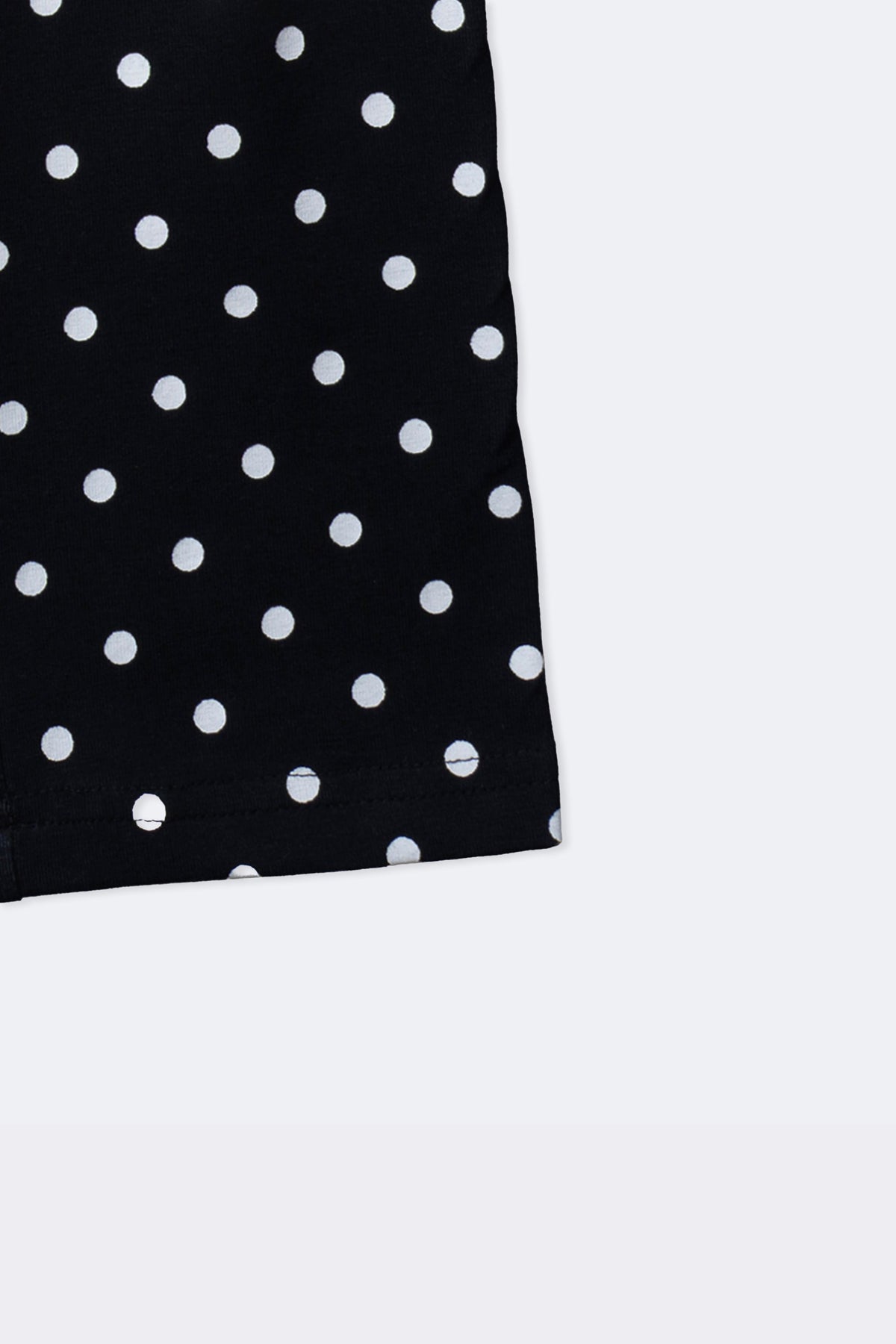 Black polka dot leggings with cuffed hem and scattered white dot pattern