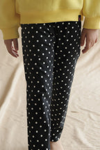 Black polka dot leggings on child, elastic waistband and slim tapered leg