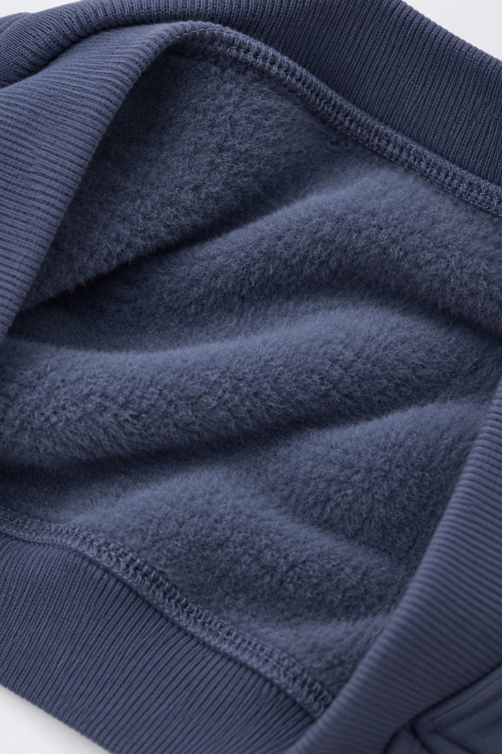 Denim blue fleece sweatshirt fabric close-up with ribbed cuffs and hem