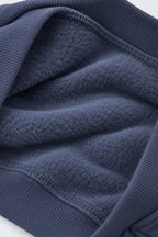 Denim blue fleece sweatshirt fabric close-up with ribbed cuffs and hem