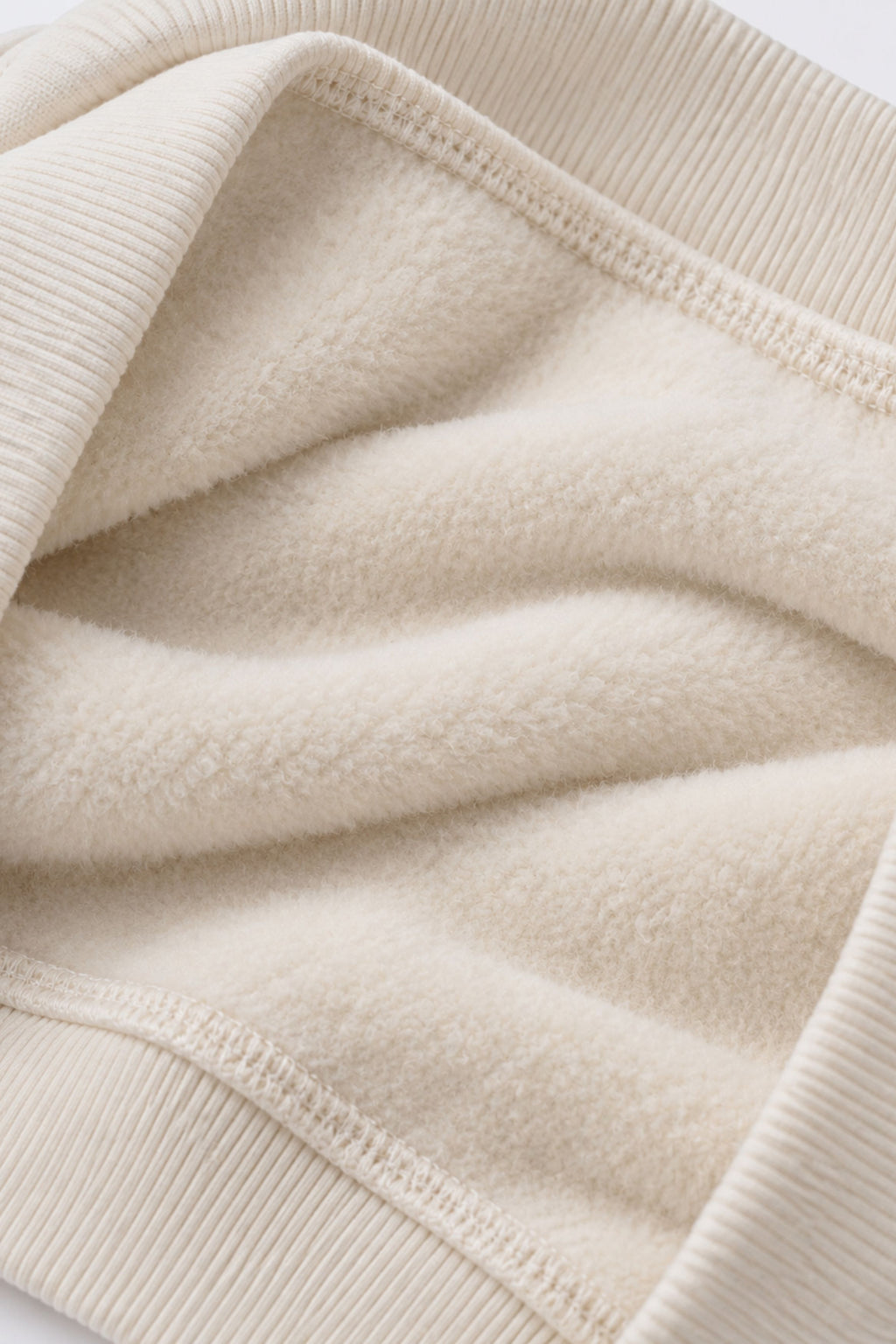 Off-white fleece sweatshirt fabric close-up with ribbed hem and cuffs