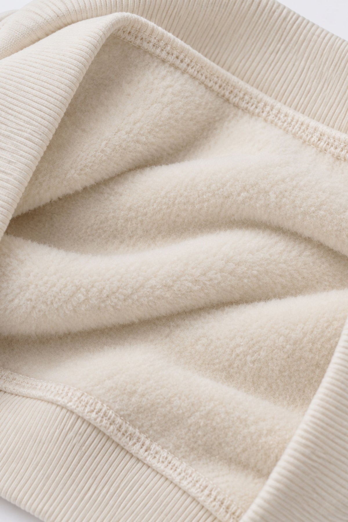 Off-white fleece sweatshirt fabric close-up with ribbed hem and cuffs