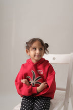 Red fleece hoodie on a child with palm tree embroidery and hood