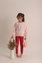 Girl wearing blush pink butterfly embellished sweatshirt with sparkle beadwork
