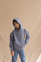 Denim blue kids hoodie with hood up and Eiffel tower embroidery, worn by child