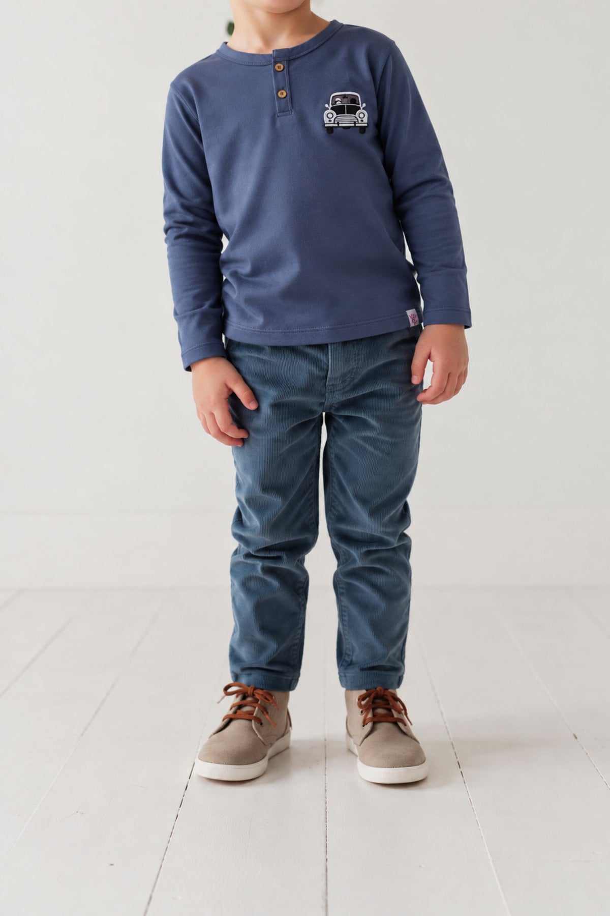 Boys denim blue long-sleeve henley top with car embroidery, worn with jeans