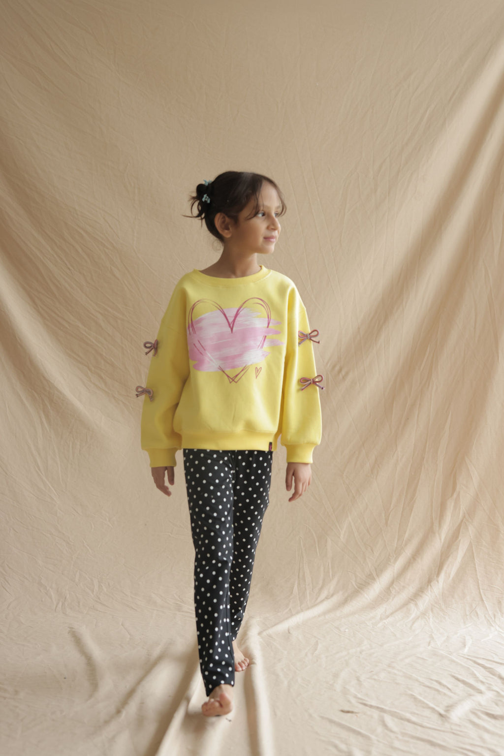 Child wearing black polka dot leggings with elastic waistband and slim fit