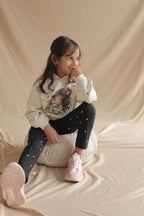 Black leggings with mini white hearts, full-length view on a girl