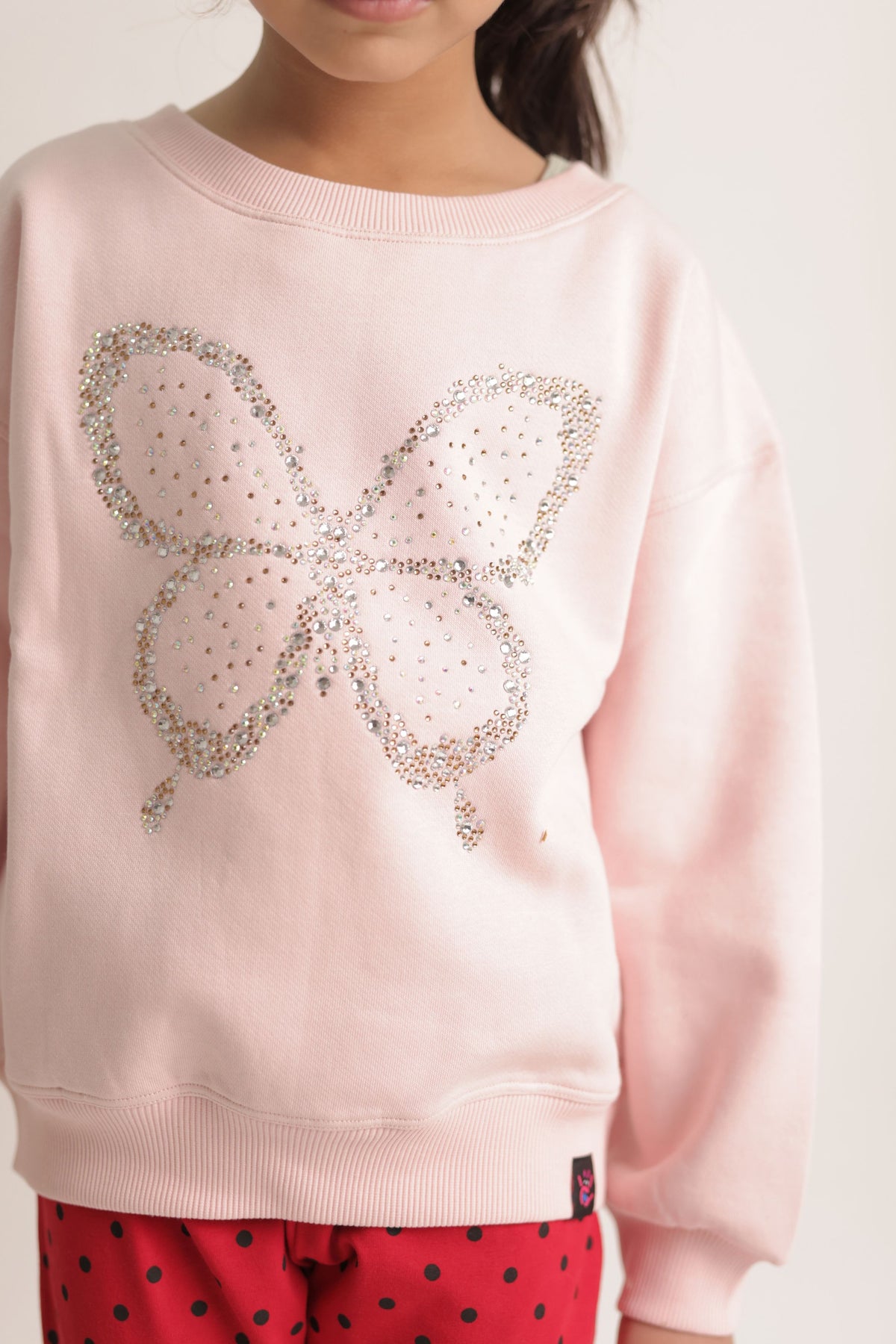 Girl's blush pink sweatshirt featuring a sparkling butterfly beadwork design