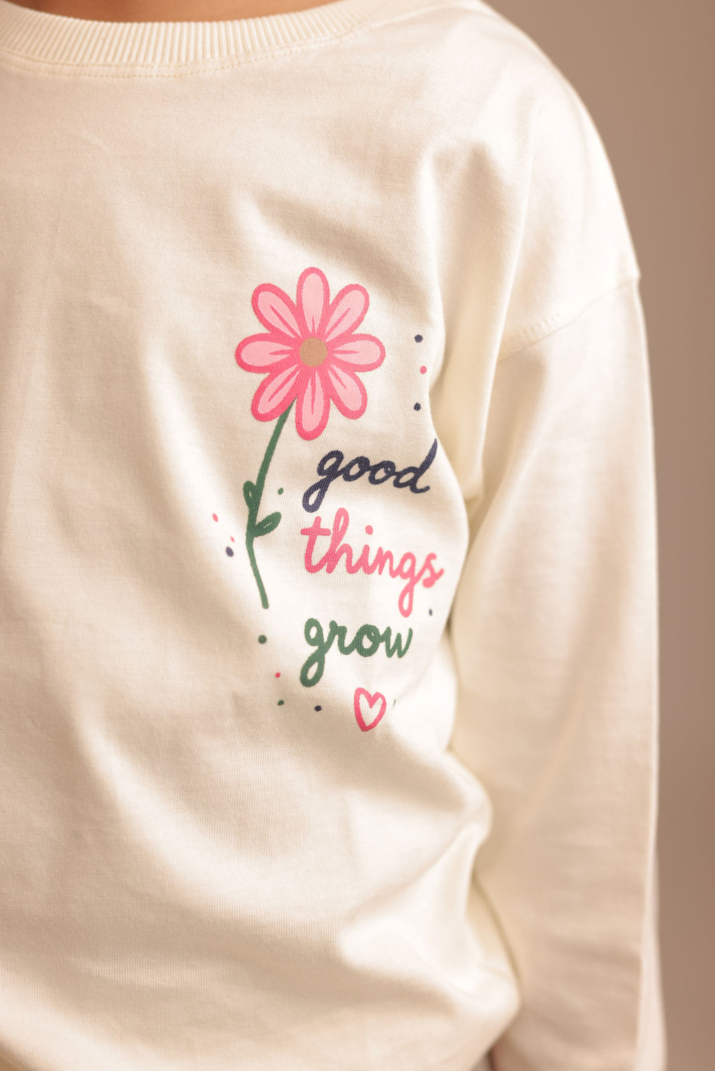 Off-white long-sleeve tee with “good things grow” pink flower dotted graphic