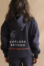 Navy hoodie close-up, back view: Explore Beyond with Little Explorer print