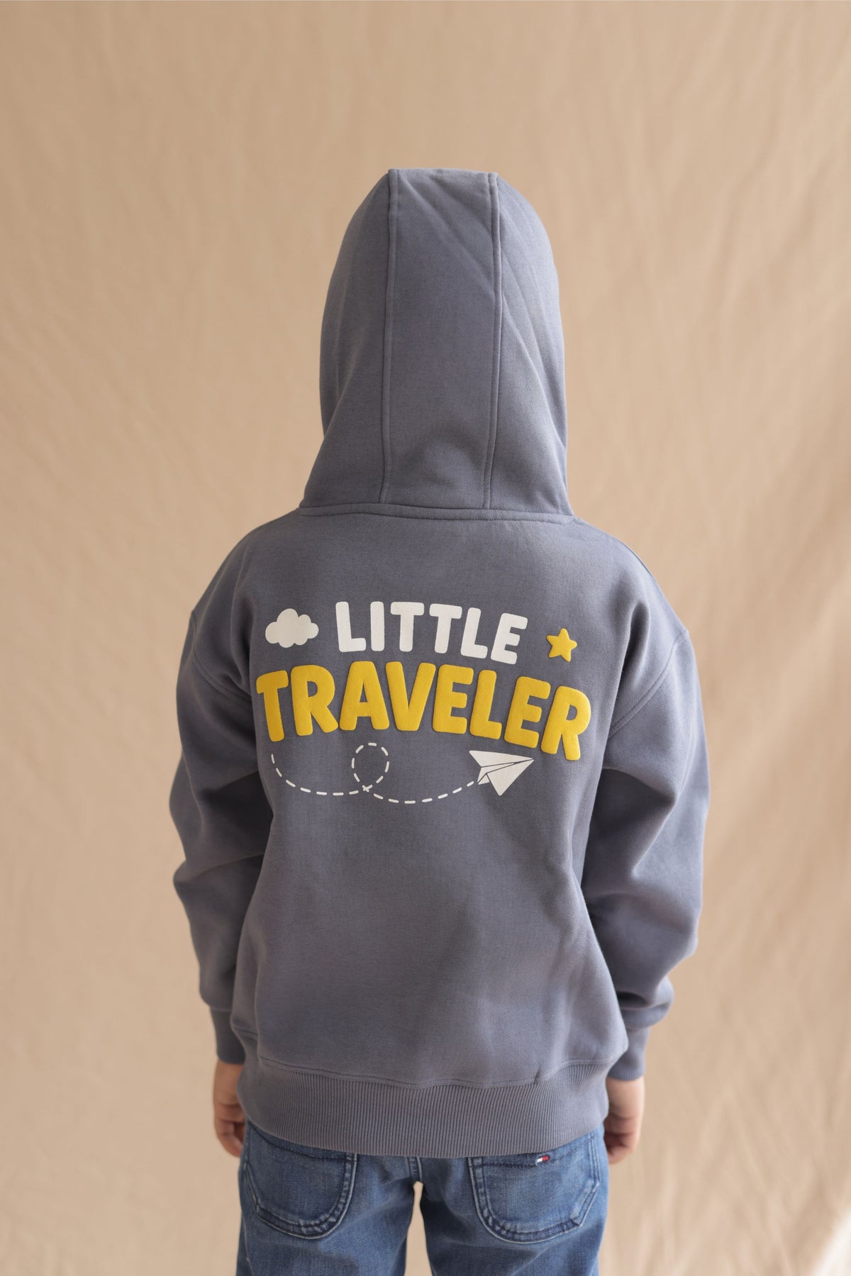 Denim blue kids hoodie back view with 'LITTLE TRAVELER' print and dotted path
