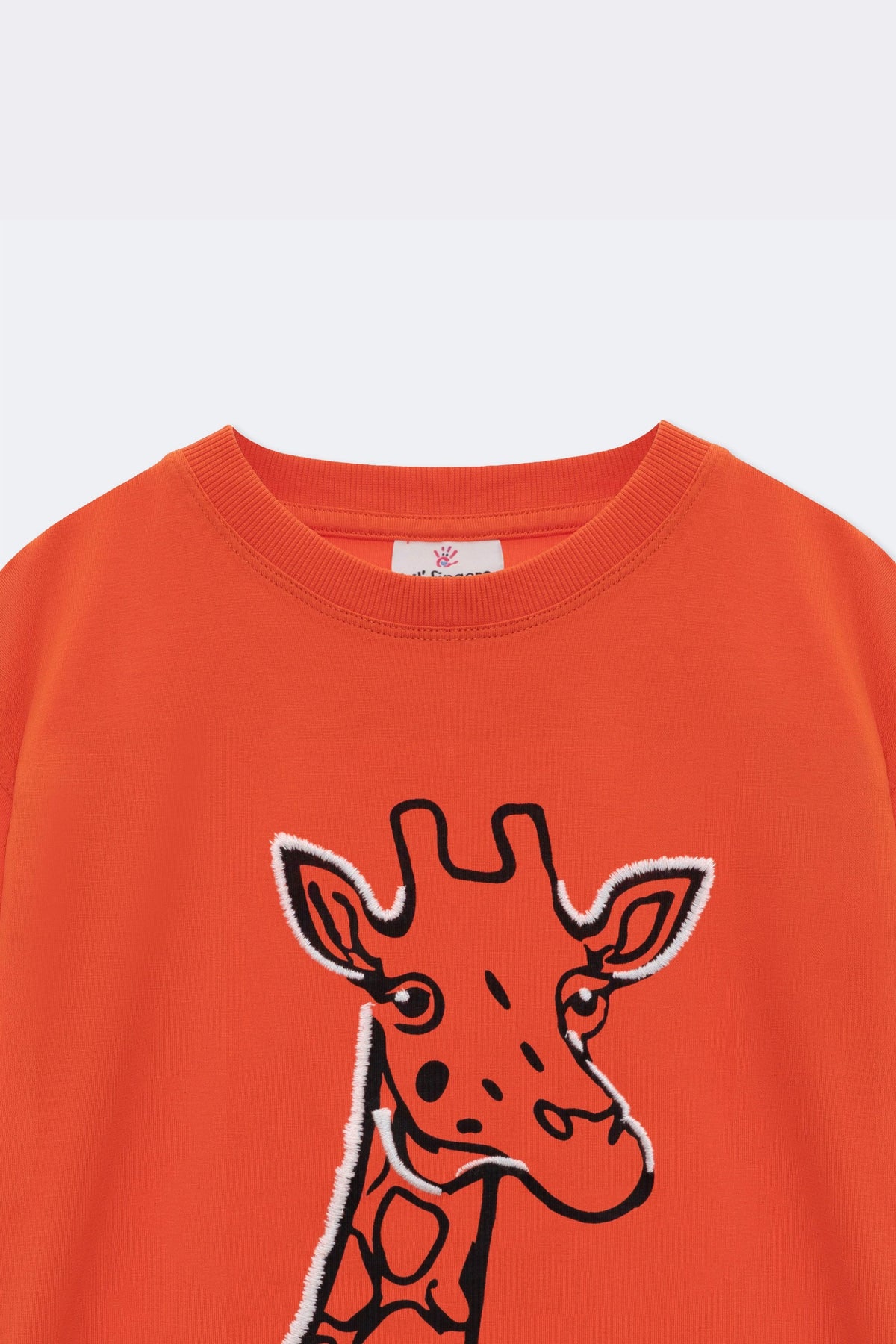 Orange comfort tee close-up: embroidered giraffe graphic on the front