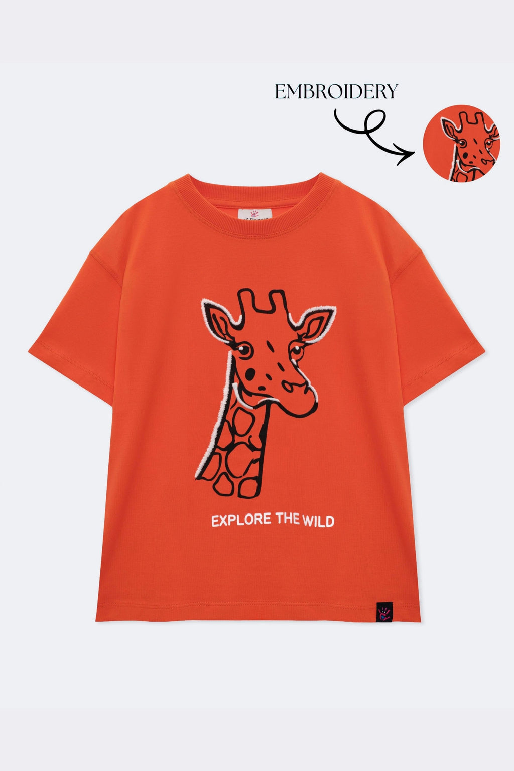 Orange comfort tee with embroidered giraffe outline and 'EXPLORE THE WILD' text