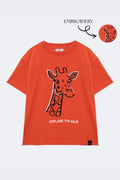 Orange comfort tee with embroidered giraffe outline and 'EXPLORE THE WILD' text