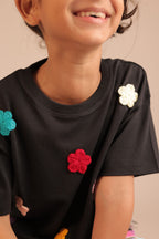 Black tee with colorful crochet flower appliques on front and shoulder