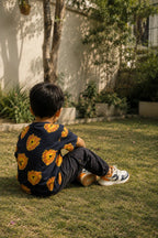 Dark navy oversized t-shirt with yellow and orange lion face print, worn by child