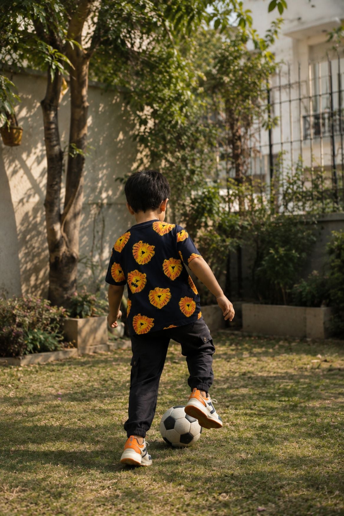 Dark navy oversized t-shirt with lion face print, worn by child in motion