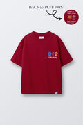 Red comfort tee with 'COLOURS' puff print and smiley/flower icons on chest