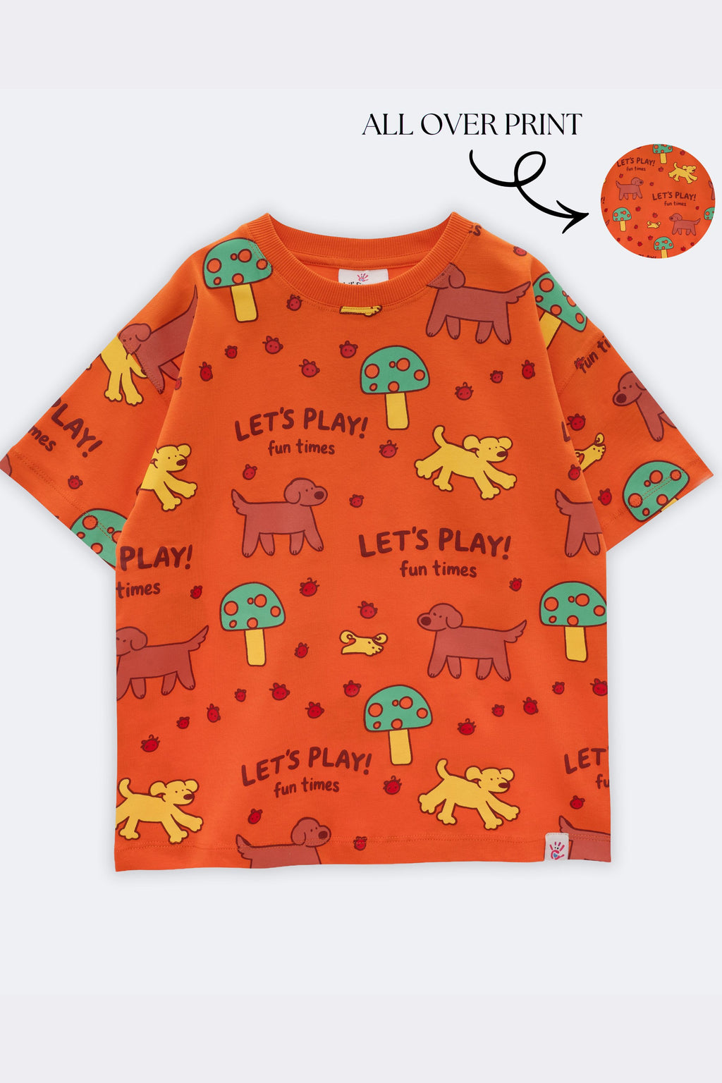Orange kids all-over print comfort tee with repeated “Let’s Play!” animal graphics
