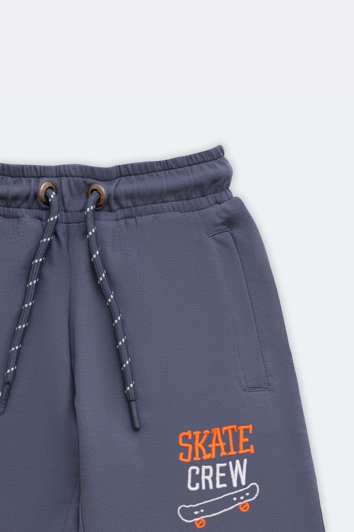 Denim blue track pants with drawstring waistband and skate-crew logo embroidery