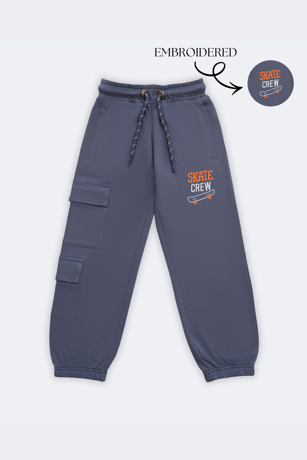 Denim blue track pants with dual cargo patch pockets and skate-crew embroidery